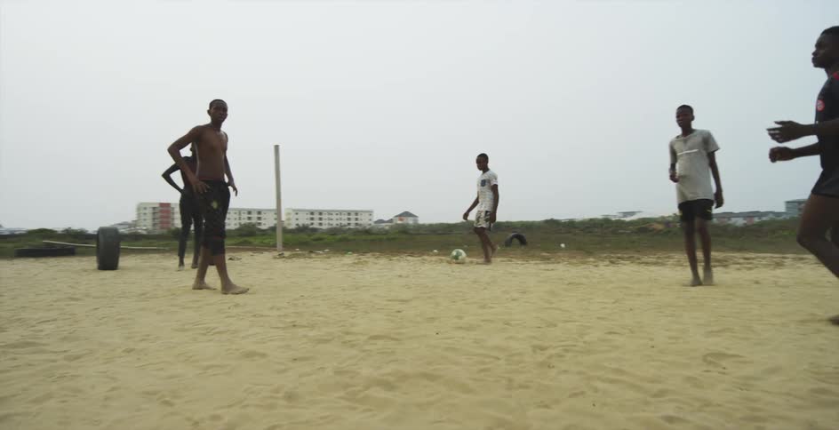 Group of young men playing soccer over the sand