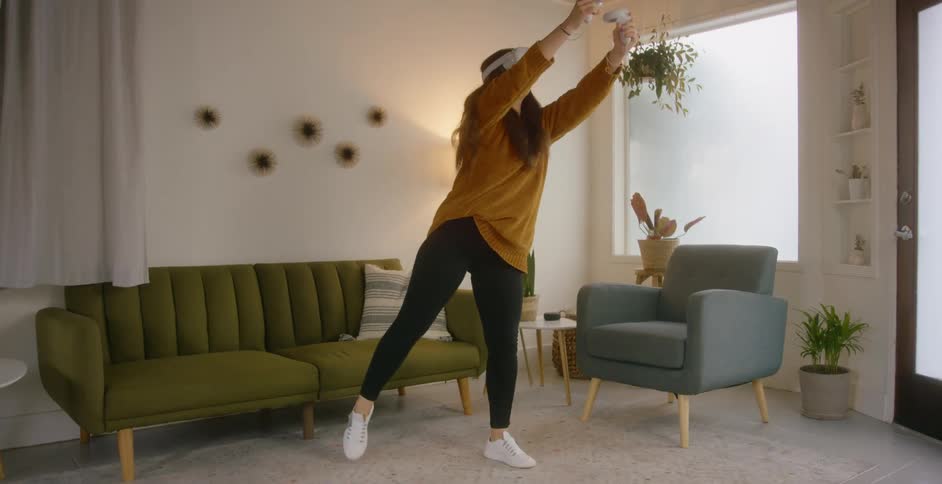A woman in a room with a virtual reality headset with a wall and window in the background