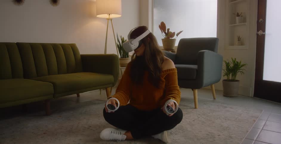 A woman in a room with a virtual reality headset with a wall and window in the background
