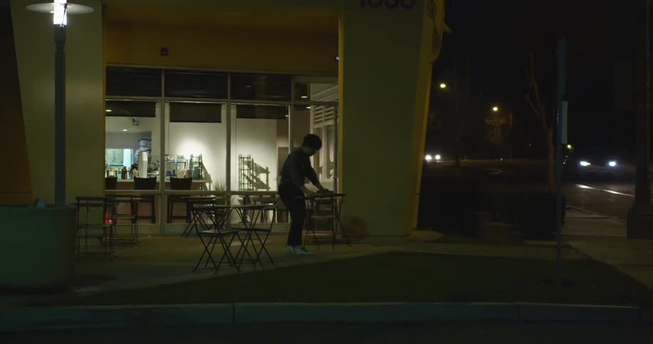 A man is setting tables outside of his restaurant