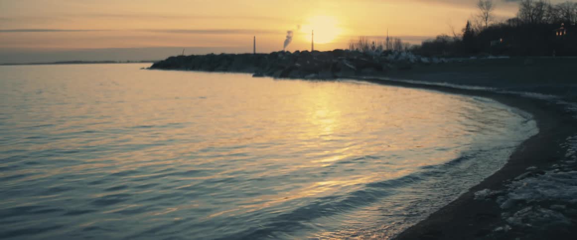 View of a bay with still ocean at sunset