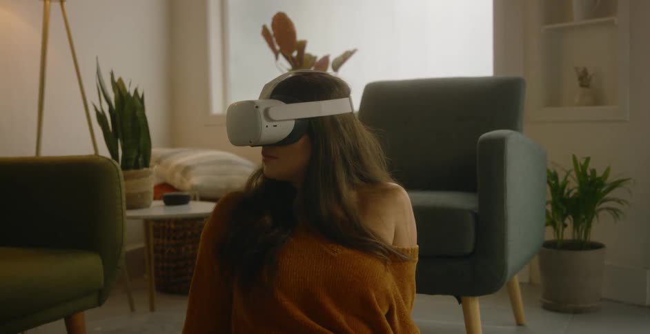 A woman sitting in a living room with a vr headset