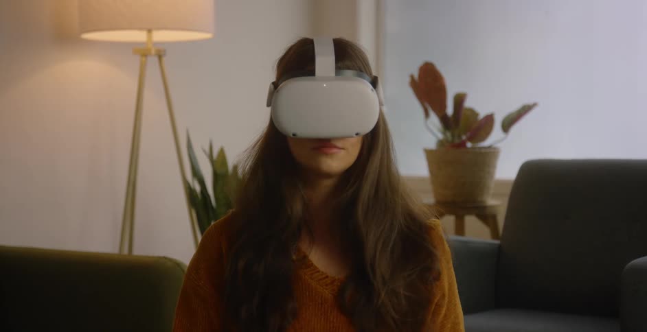 A women is in a living room with virtual reality glasses on