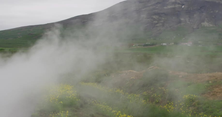 Mists roll across a mountain field during the day