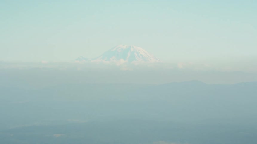 Dramatic zoom on a snow covered mountain on the distance