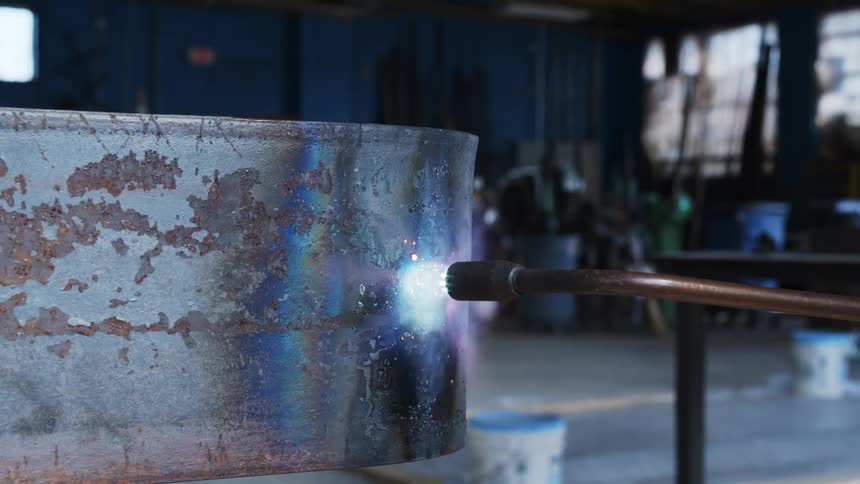 A torch being used on a piece of metal in a warehouse
