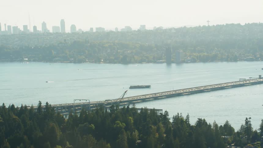 Aerial shot of cars driving over a bridge which is made on top of a river