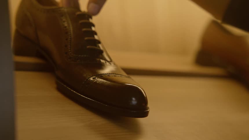 An employee grabbing a shoe on a shelf