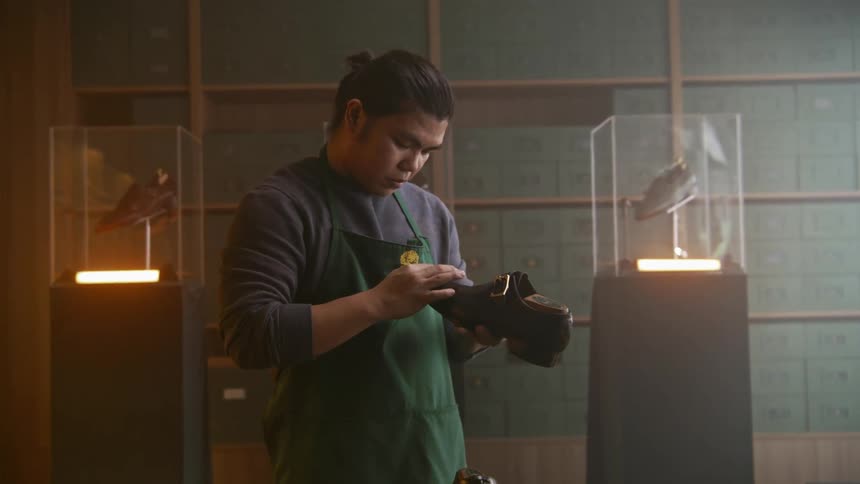An employee putting something on shoes in a room