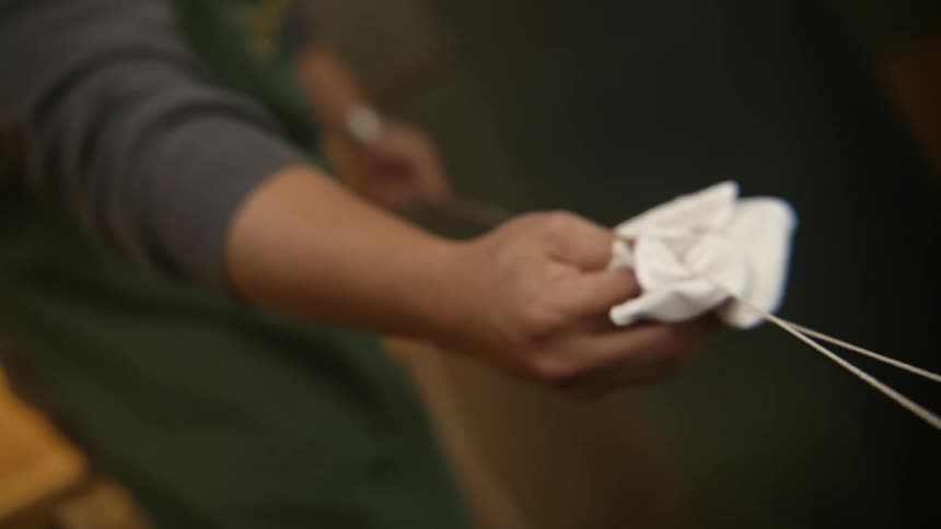 A man cleans sharp skewers with a white cloth
