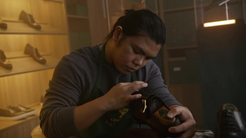 A man is cleaning a shoe indoors