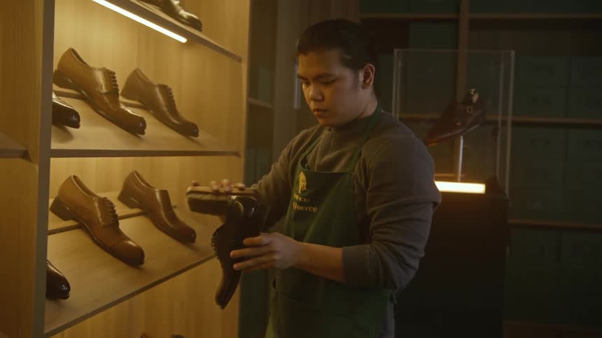 A man shining a leather shoe in a shoe store