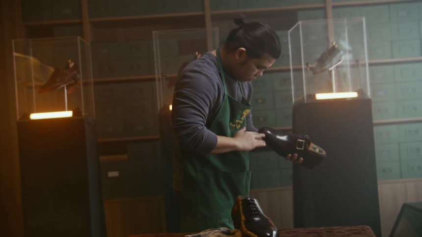 A man is polishing a leather shoe