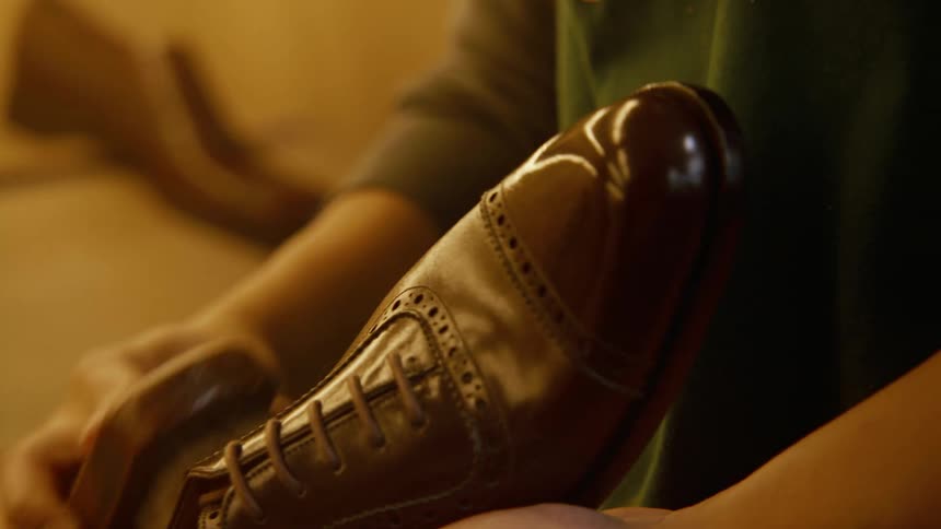 A person is cleaning a shoe with a scrubber