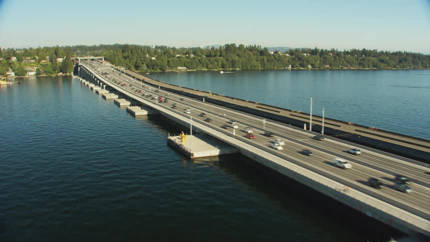 An aerial view of cars traveling over a large bridge spanning a body of water