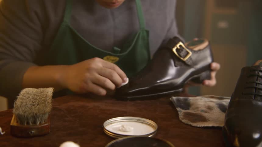 An employee brushes and shines some shoes