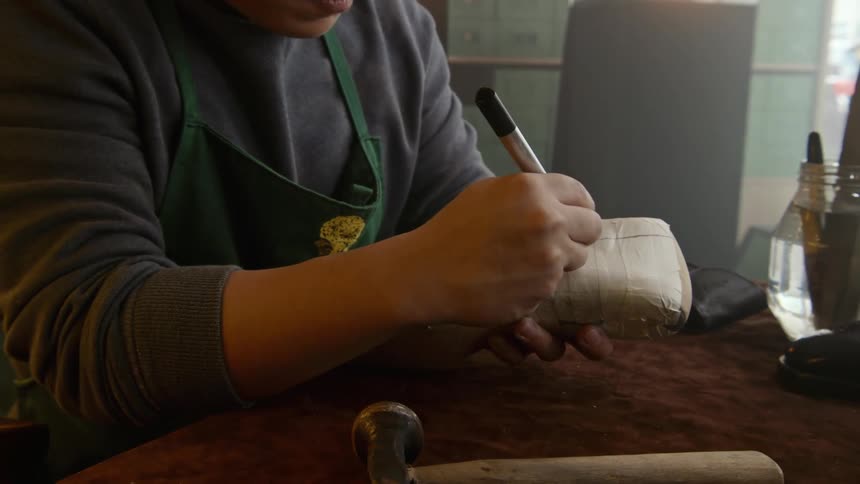 A man is writing on a package with marker