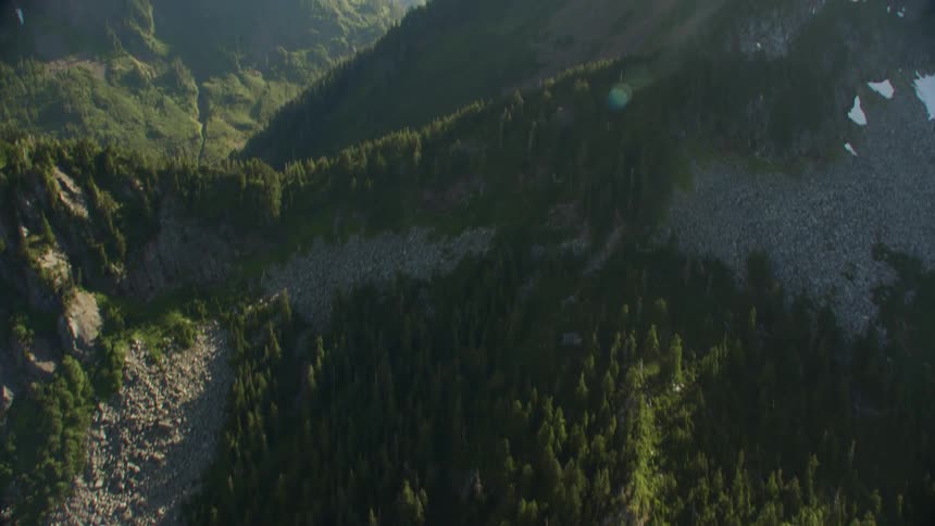 Dense trees line the bottom and slopes of tall mountains