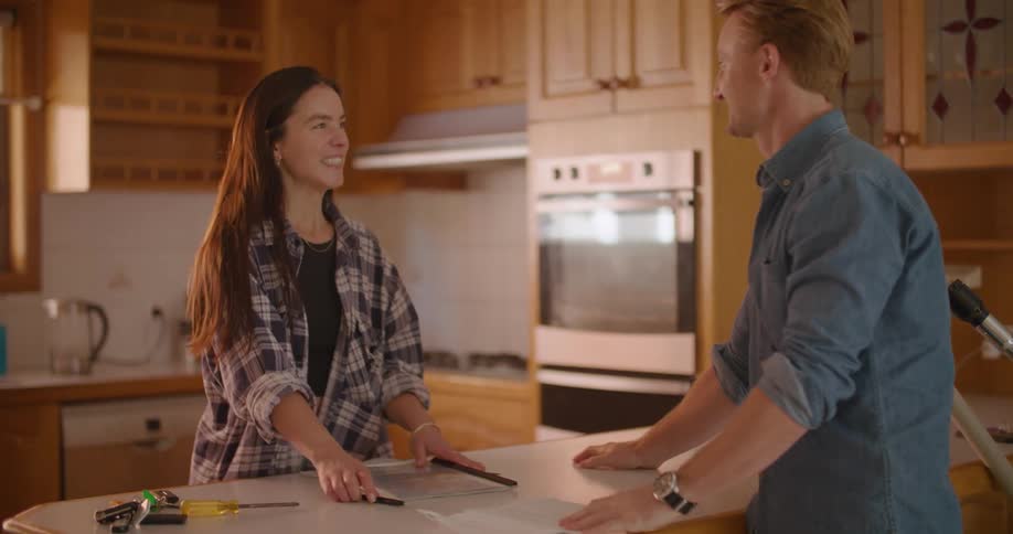 Young couple talking on the kitchen at home