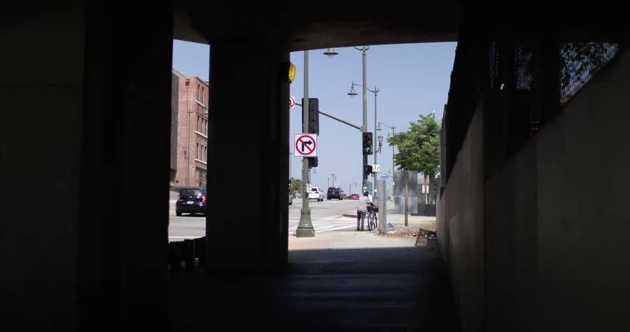 Cars passing by on a city street from inside a covered area