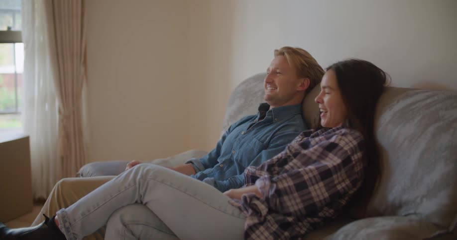Man and woman are sitting on a couch together indoors