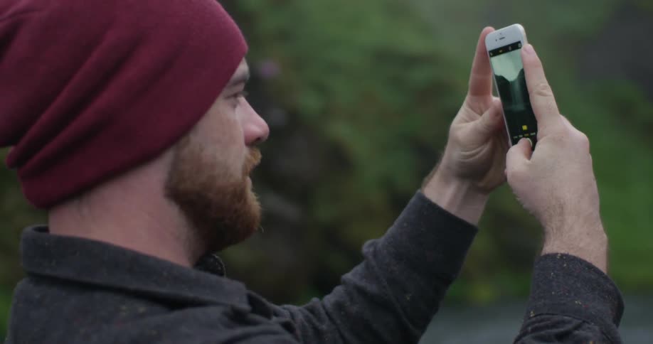 A man is using a phone to take a photograph