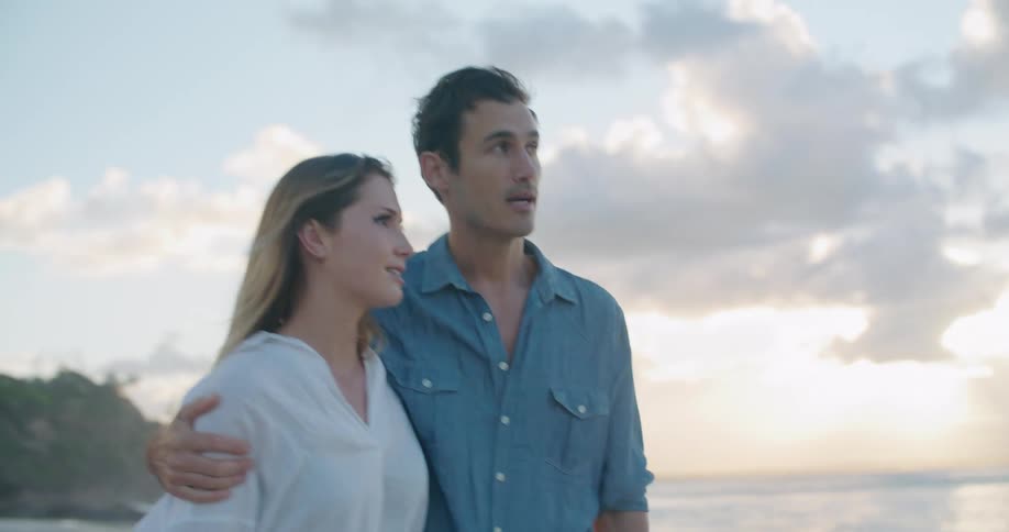 Two people walking down the beach