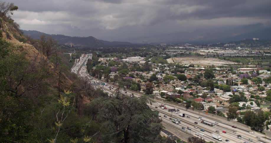 Traffic on a large city highway on a very cloudy day