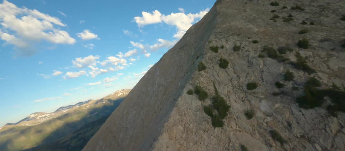 The camera flies high above a chain of sprawling mountains
