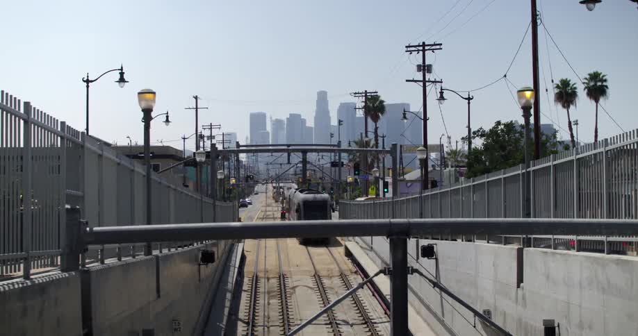 A train goes by with cars on the street on both sides