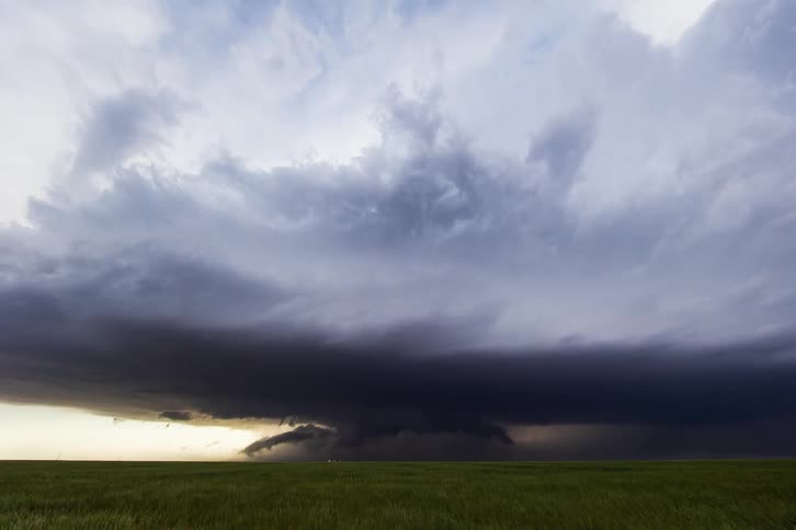 A time lapse shows large storm clouds passing over expansive grasslands