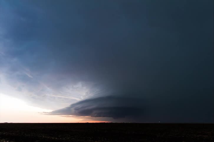 Tornado clouds move in rotation as lightning flashes