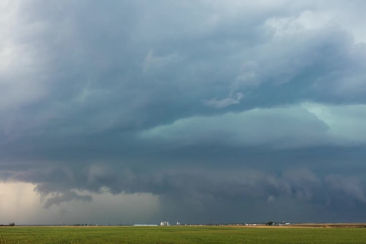 Storm clouds gather over a small town in the countryside
