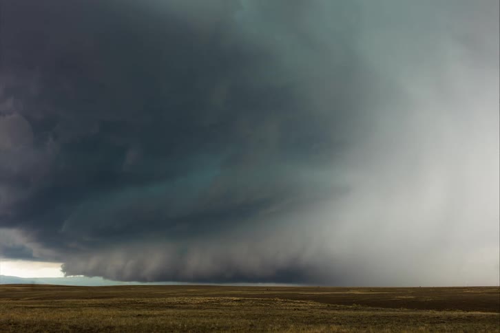 Tornado clouds move in rotation above the ground