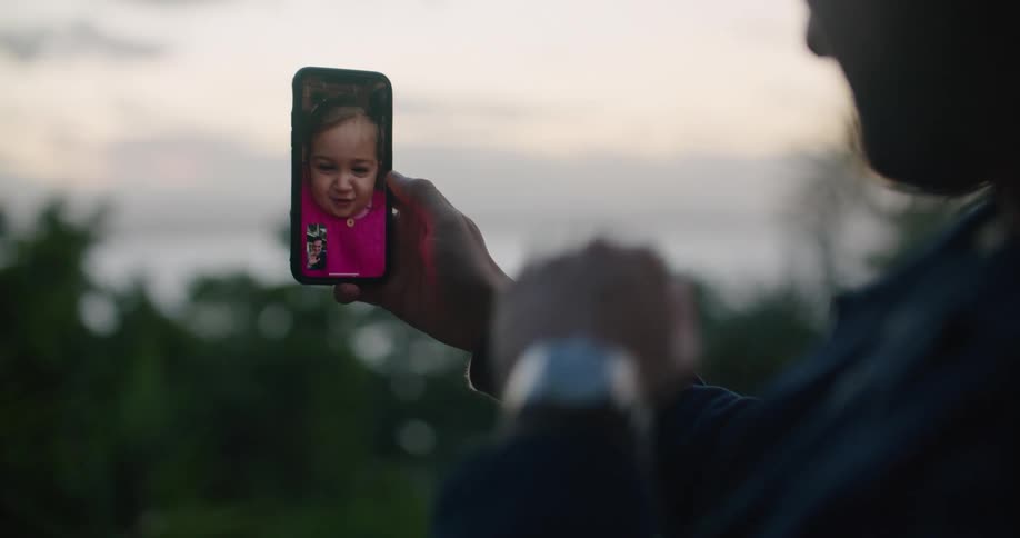 Person has video call with girl on mobile phone near shore