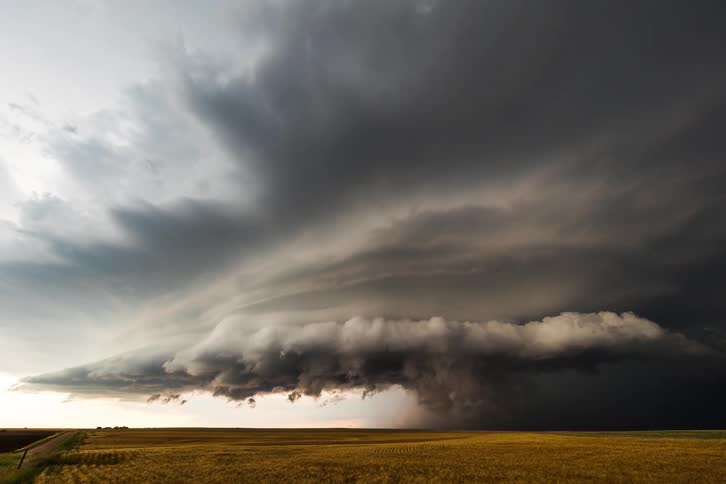Storm clouds are in rotation as a tornado moves on the ground
