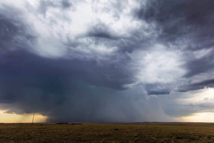 Storm clouds pouring rain over a field in the countryside