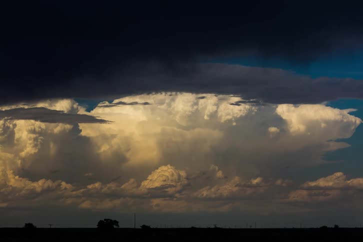 A landscape with silhouette of trees with the sky and clouds in the background