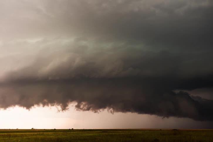 A view of storm clouds forming above grass