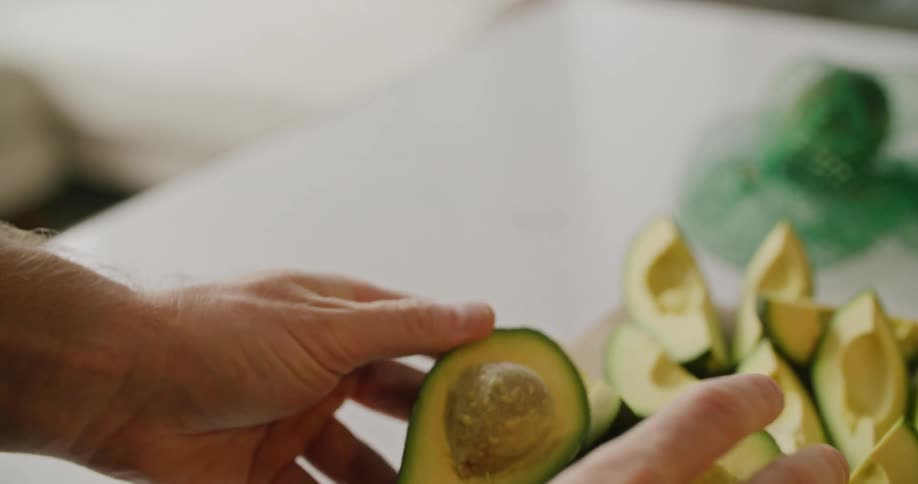 A man is opening avocados on the table