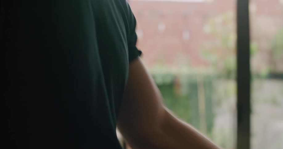 A man peels and cuts a piece of avocado in his home kitchen