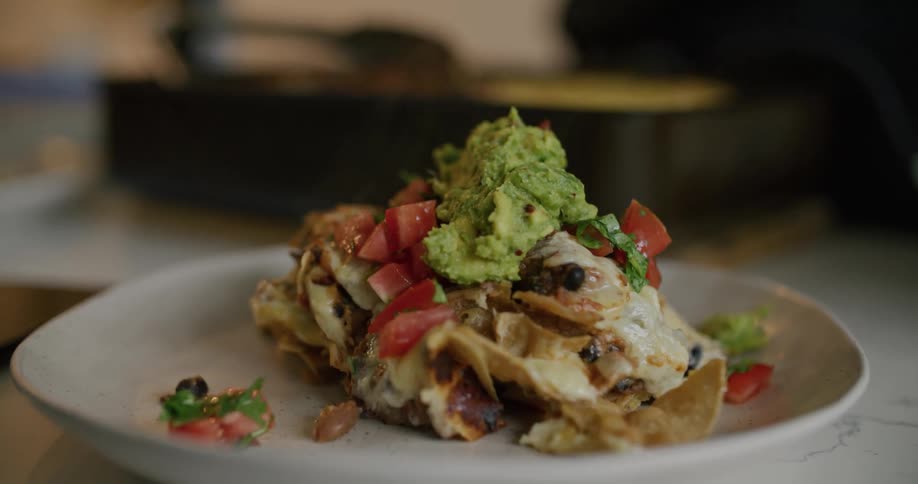 A person puts guacamole on top of a meal
