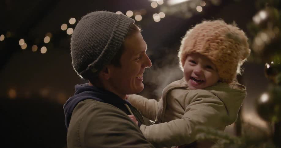 Man holding toddler as they both smile and laugh