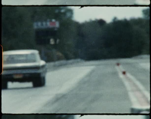Vintage race cars speeding down the race track caught on vintage film