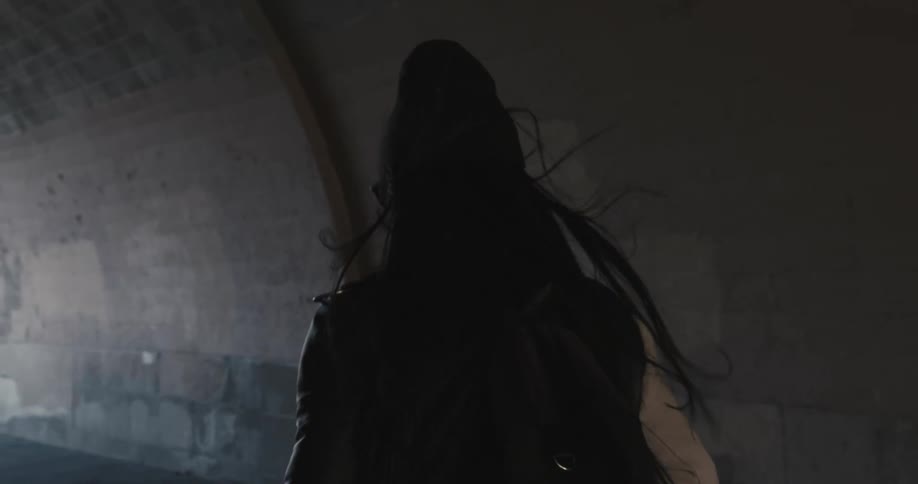A woman walking out of a tunnel
