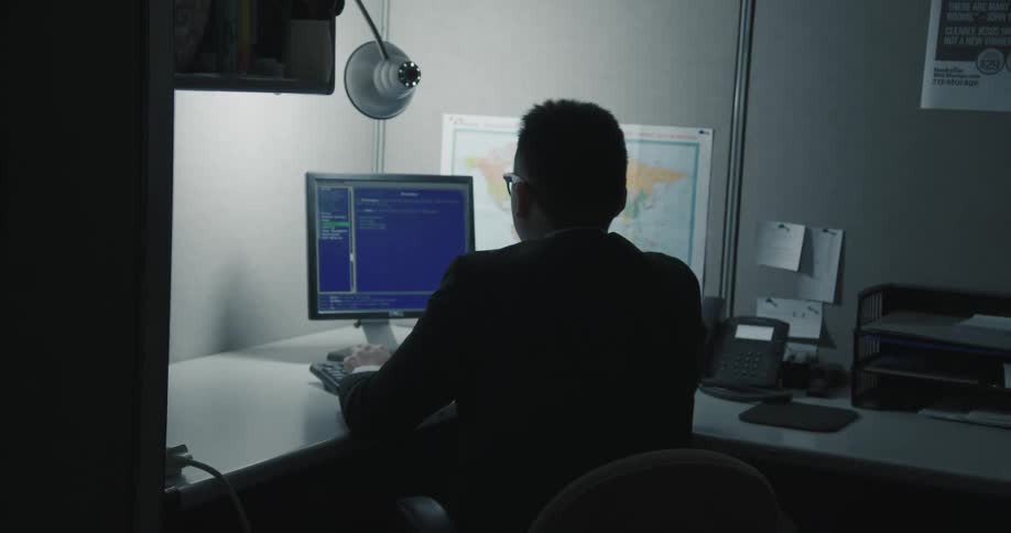 Man working on a computer on a dimly lit office