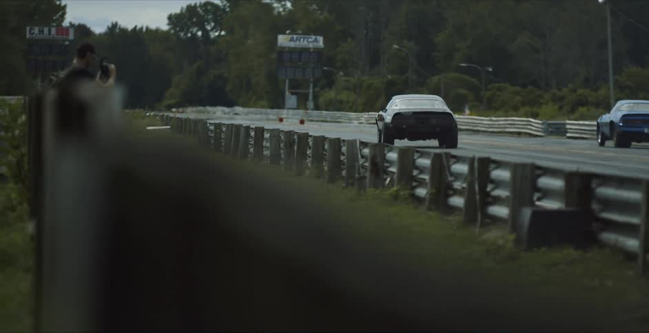 Two sports cars racing down a race track