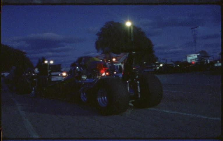 People walking on a race track with race cars lined up