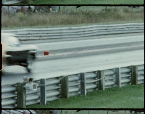 A black race car drives down the lane