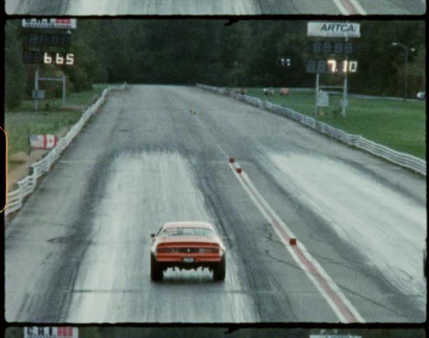 Two cars race down track toward woods